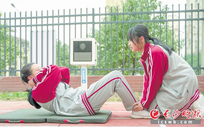 　　图为学生在练习仰卧起坐，旁边的智能摄像头实时记录她的数据。　　长沙晚报全媒体记者 易亿 摄