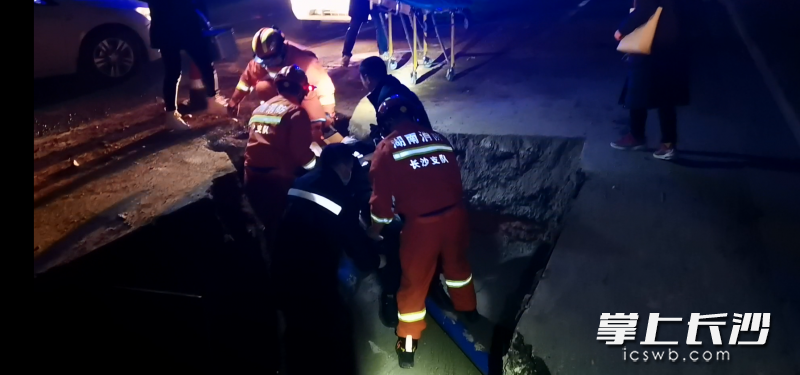 救援现场，消防指战员从坑内将被困人员救出。视频截图