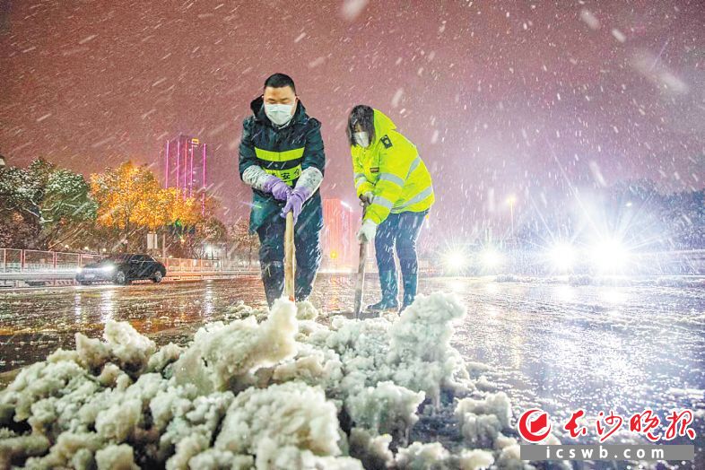 27日凌晨，城管工作人员正在银杉路清理路面积雪。长沙晚报通讯员 周全 摄