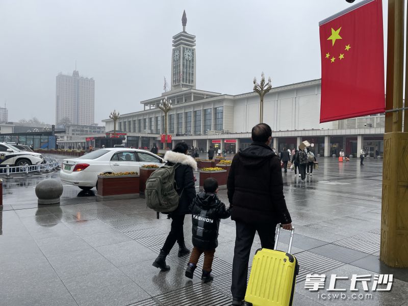 春运首日，在长沙火车站，一对夫妻牵着孩子准备进站乘坐火车。 