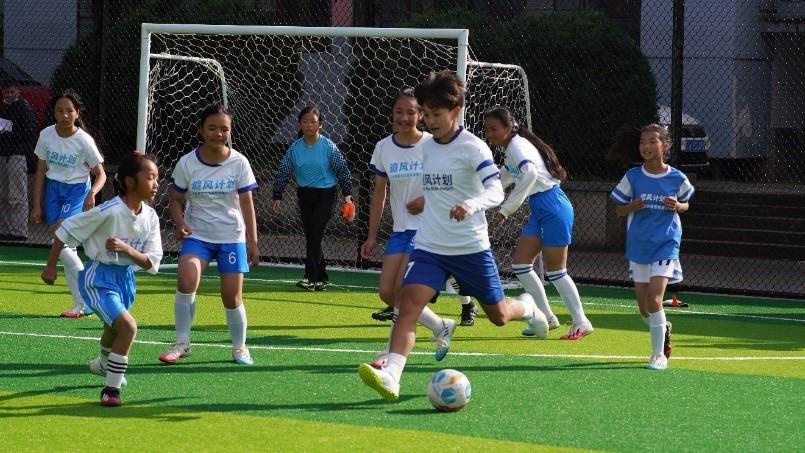 王霜和女孩们一起踢球。