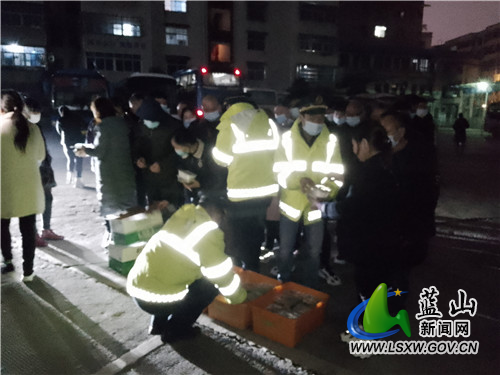 图为乘客在车站排队领取晚餐.jpg