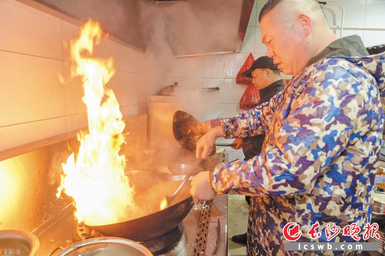 上岸渔民谢兴富成了一名大厨，小年当天，他在自己开的洪州鲂饭店内掌勺做团圆饭。　　长沙晚报全媒体记者 陈飞 摄
