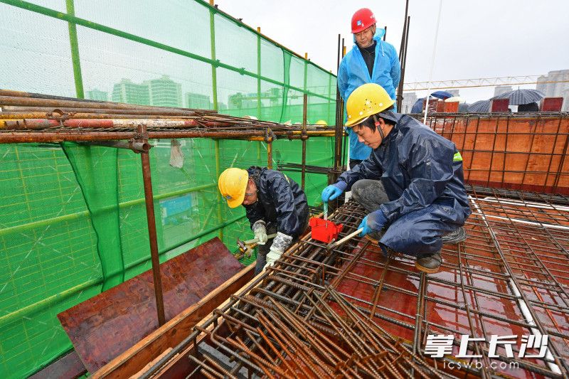 1月28日，麓山国际学校二小项目，工人们在冒雨紧张施工。当天，该项目主体结构成功封顶。均为长沙晚报全媒体记者 王志伟 摄