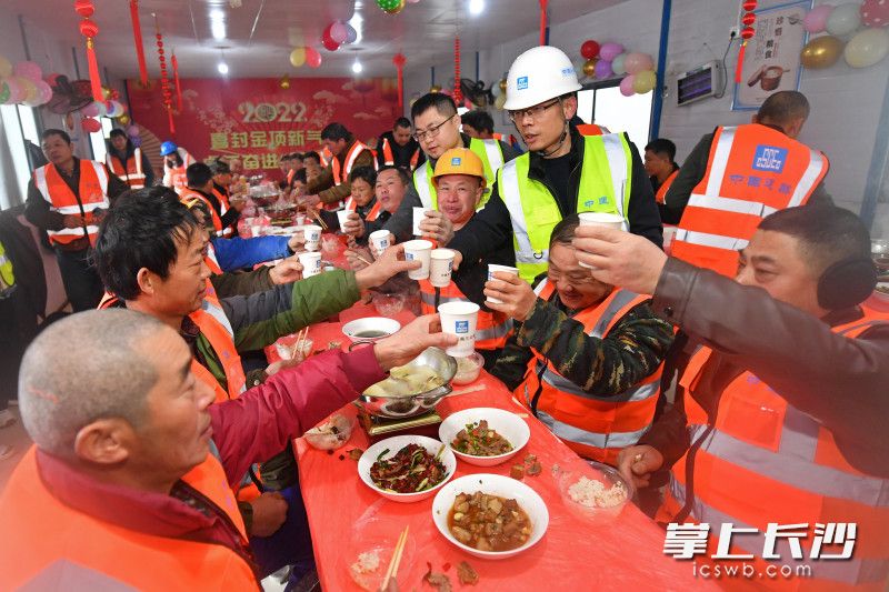 工地生活区内，项目部为辛勤劳动的工友准备了丰盛的团圆饭，食堂里张灯结彩，处处洋溢着春节的喜庆。