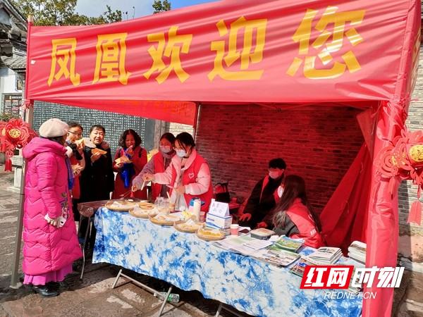 春节期间，青年志愿者为游客提供糍粑美食品尝。_看图王.jpg