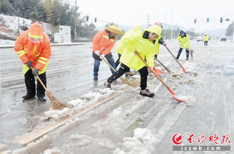 青竹湖路东延线，环卫工作人员正在清除路面积雪，保障道路畅通。长沙晚报全媒体记者 邹麟 摄