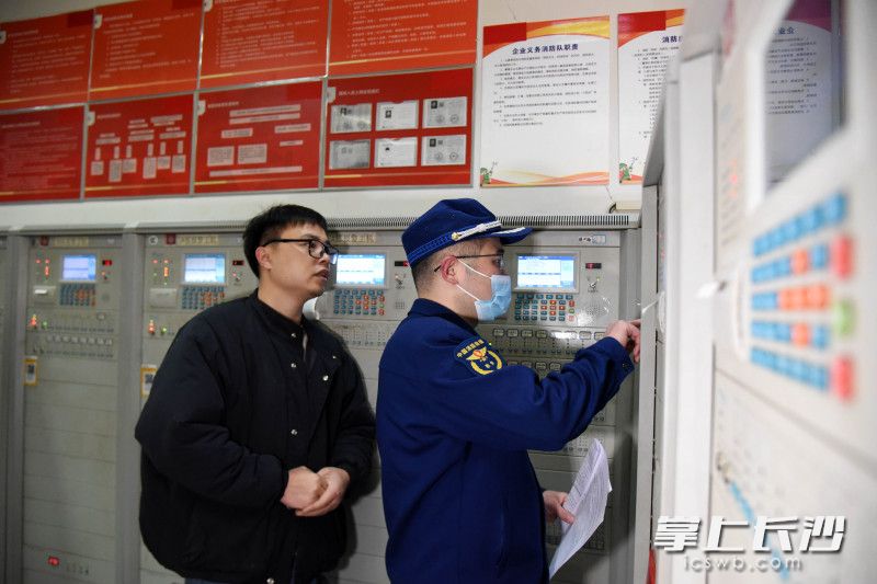 消防监督员对消防控制室主机上的故障点进行复查。