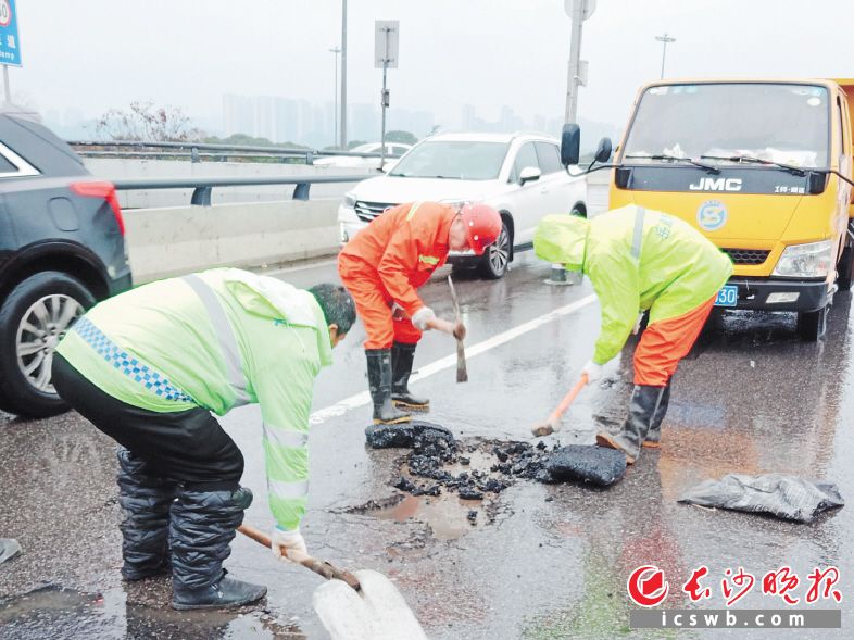 雨雪天气后，市政工人迅速修复路面坑洞。　　均为市城管执法局供图