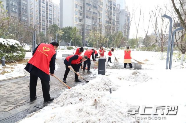 长房物业组织党员志愿者展开除雪活动，保障小区居民出行。长房集团供图