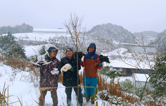3人春节期间在农场雪景中合影。受访单位供图