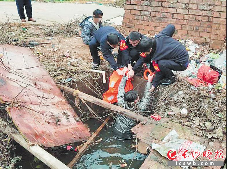 　　民警将落水市民从水坑里拉上来。长沙晚报通讯员 覃亚林 唐采苓 供图