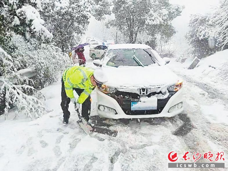 22日下午，长沙县交警正在清理道路积雪。长沙晚报通讯员曹毅 供图