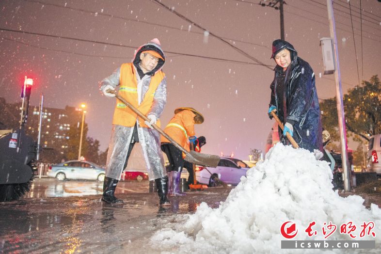 22日晚9时，在东二环荷花路口，城管部门工作人员在清扫路面积雪。长沙晚报全媒体记者 黄启晴 郭雨滴 摄影报道