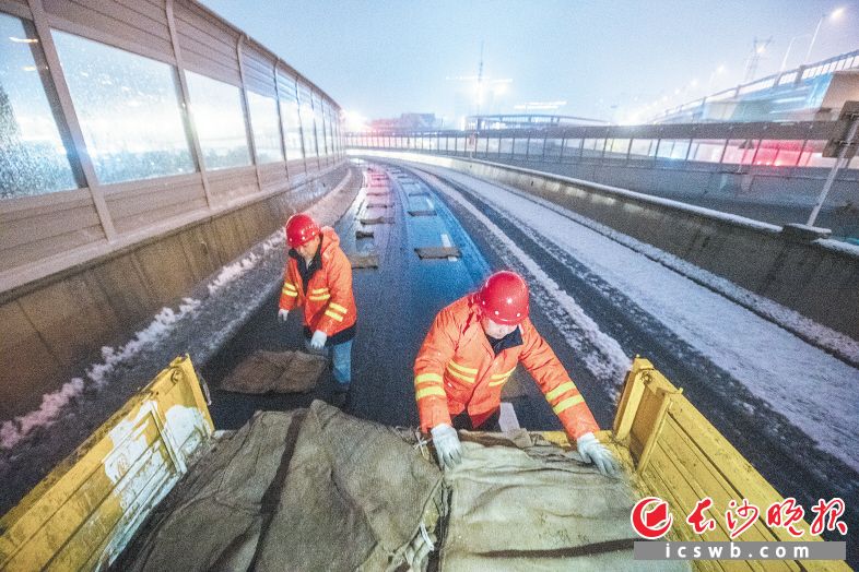 22日晚11时20分，在万家丽高架三一大道互通，城市桥梁隧道事务中心工作人员在给匝道铺设麻布袋。长沙晚报全媒体记者 黄启晴 郭雨滴 摄影报道