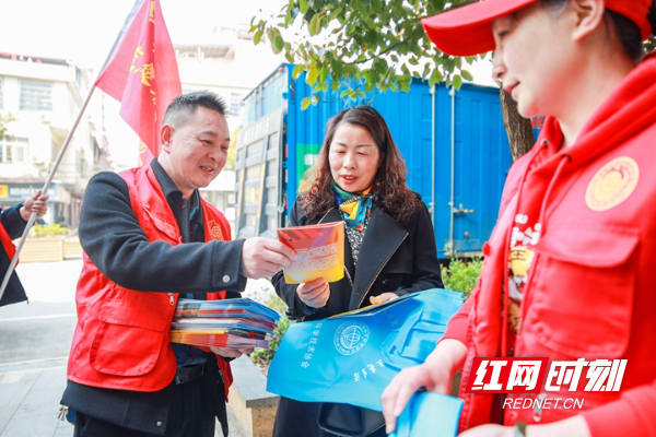 3月4日，蓝山县塔峰镇湘粤路，志愿者在为市民发放科普手册。.jpg