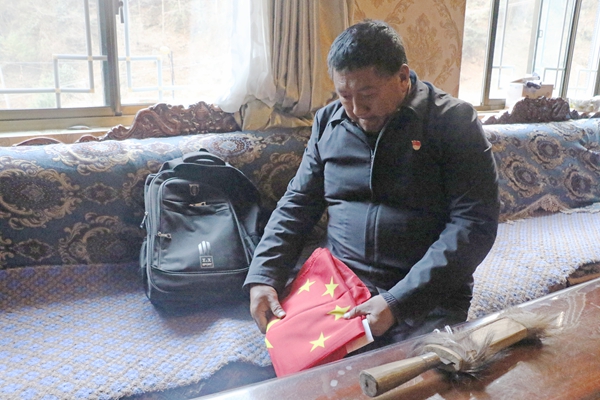 4图为格桑旦增出门前正在整理国旗_副本.jpg