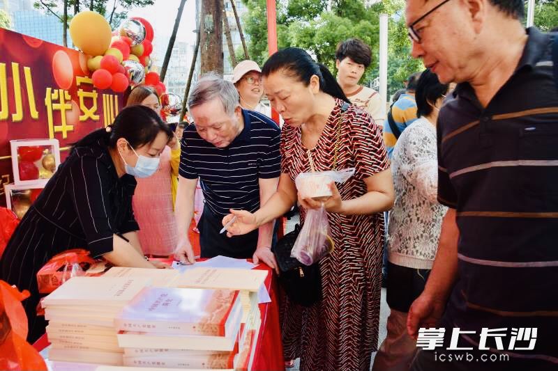 松桂园商圈党群服务中心向居民和楼宇白领赠送党史学习书籍。 全媒体记者 李卓 摄