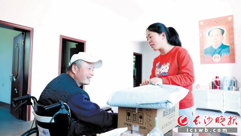 3月9日,邱蓉(右)将代收的快递送到刘露手中。 长沙晚报全媒体记者 宁霞 摄