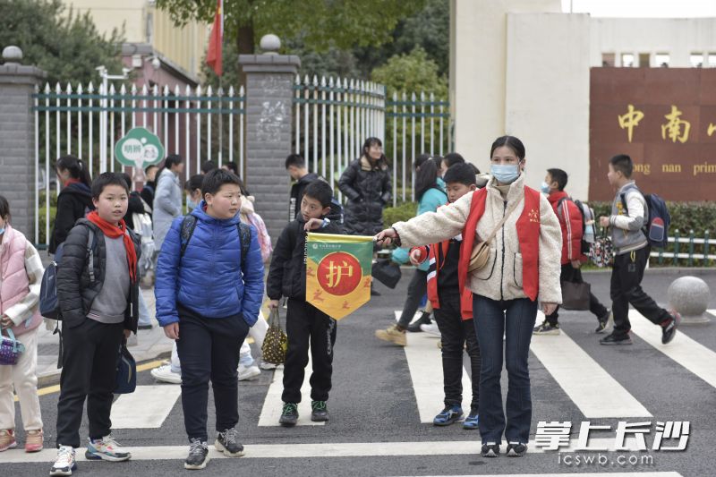 在中南小学东门，家长志愿者引导学生安全过斑马线。长沙晚报通讯员 李杰 摄