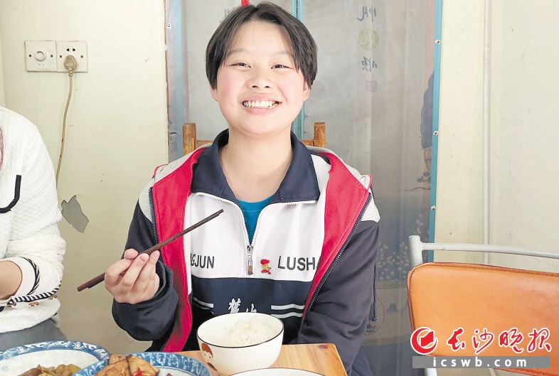 　　张雅萱在“共享奶奶”家吃饭，露出开心的笑容。