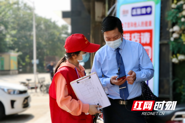 长沙县㮾梨街道16号网格党支部书记黄璇在辖区内检查门店疫情防控工作开展情况。赵佳慧 摄.jpg