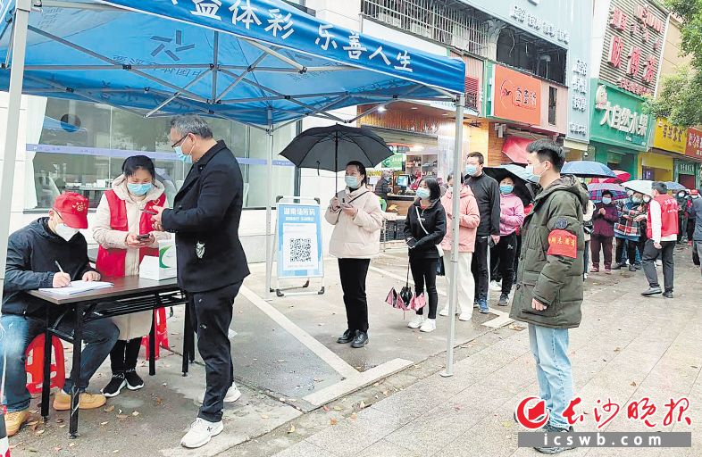 　　芙蓉区湘湖街道，社区居民有序排队接受核酸检测。街道干部蒋恋峰（右一）在现场协助维持秩序。长沙晚报通讯员 林秀云 摄