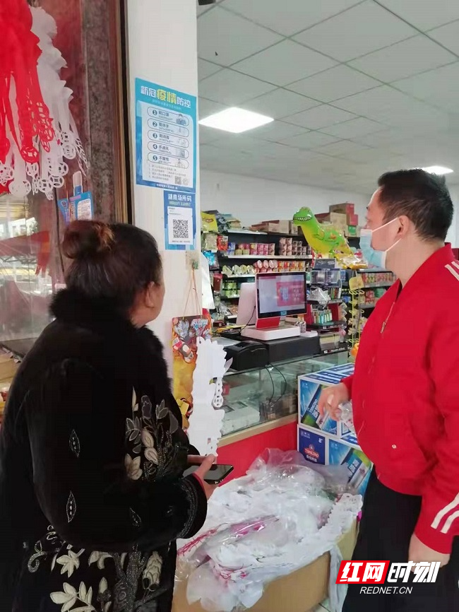 政府干部检查商铺张贴场所码及实际使用情况.jpg