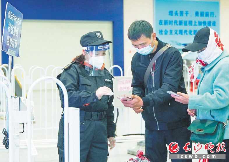 　　在长沙火车南站，保安正在查验乘客场所码的扫描情况。长沙晚报全媒体记者 刘晓敏 摄