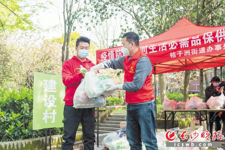 志愿者将生活物资配送至管控区市民手中。 长沙晚报全媒体记者 郭雨滴 摄