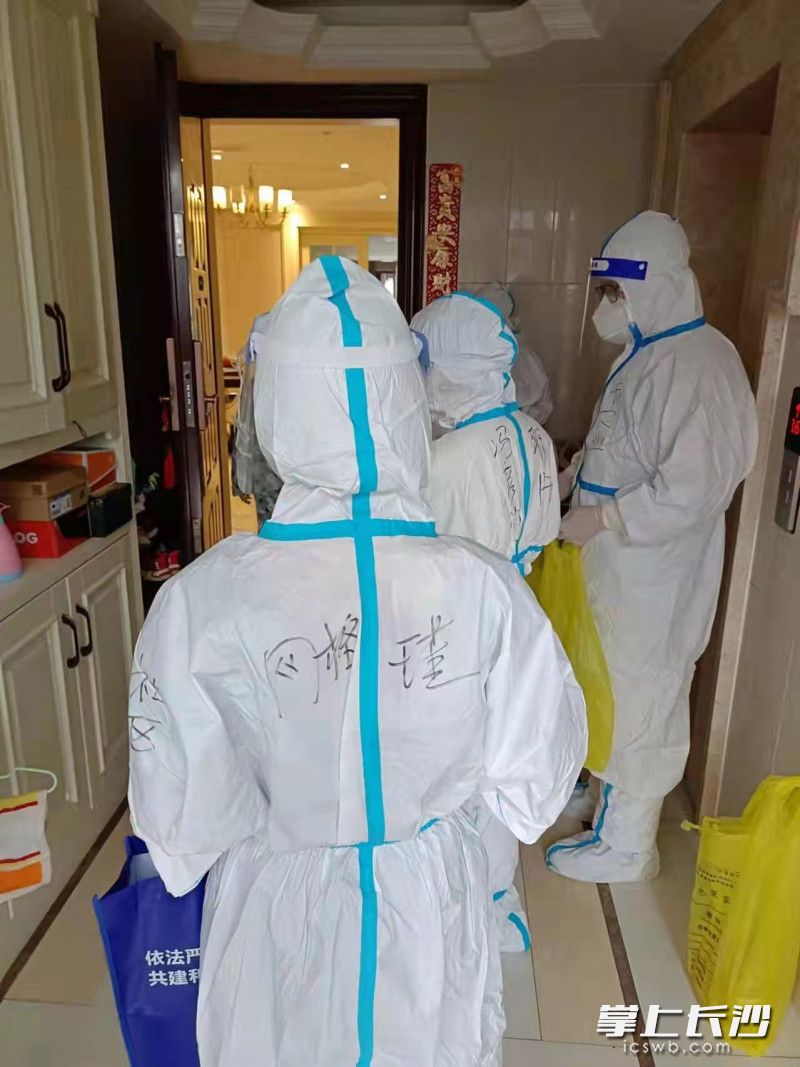 颜军协助医护人员上门对居家隔离的学生和家长进行核酸样本采集。
