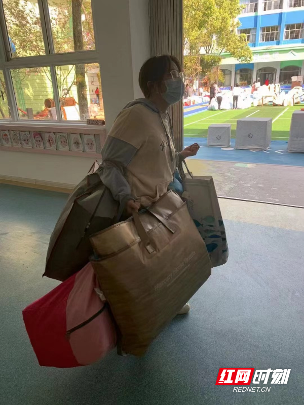 疫散复课前，怀化市幼儿园的教师化身超级大力士，将幼儿的被褥打包，让家长带回家进行清洗和翻晒.jpg