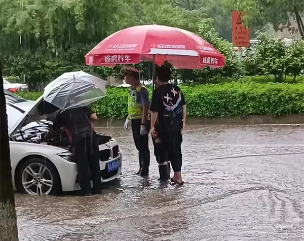 金星路佑母塘路，有些车辆在暴雨中熄火，停靠在道路中，交警现场疏导。.jpg
