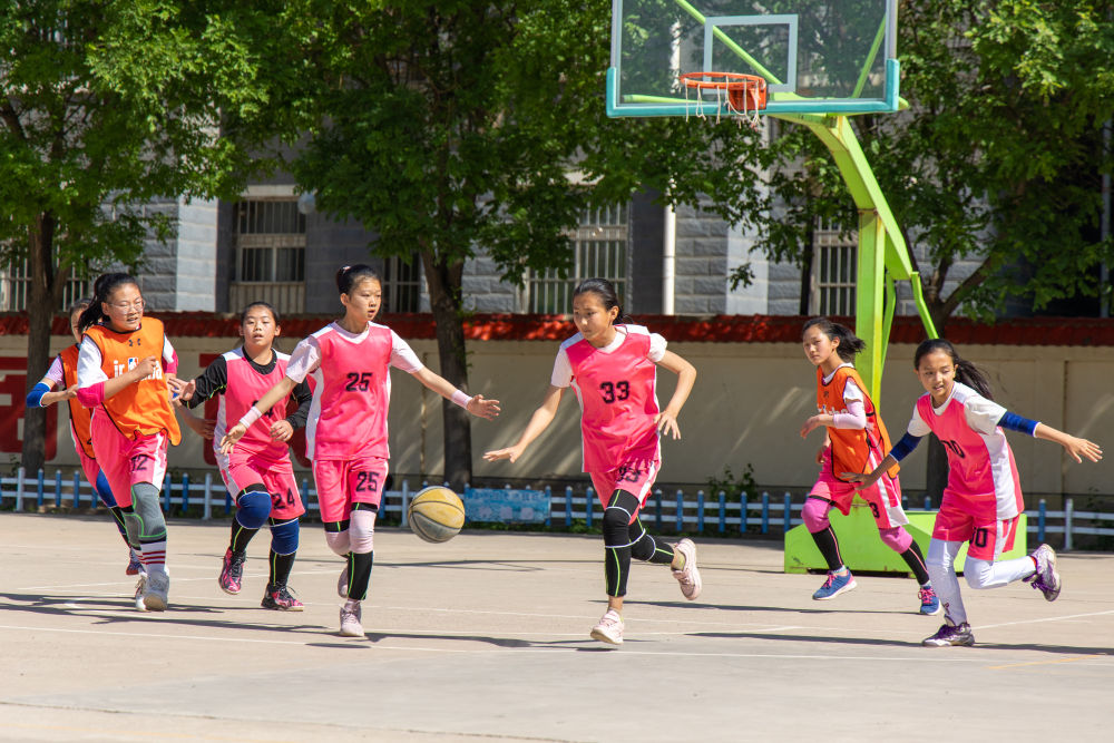 2021年5月20日，宁夏中宁县第九小学五年级篮球队女队员在体育课上打篮球。新华社记者黎广滔摄