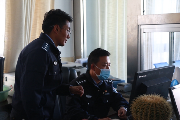 图为浪卡子县公安局办证窗口民警多吉欧珠与同事正在讨论工作.jpg