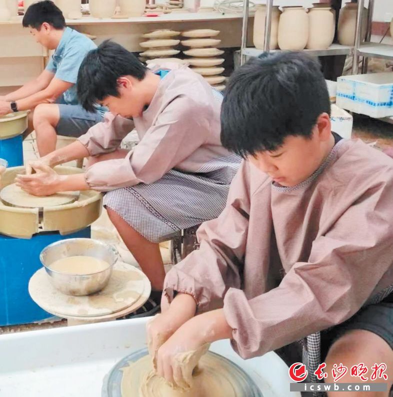 游客在艺文小镇黑石号老陶场体验制陶。