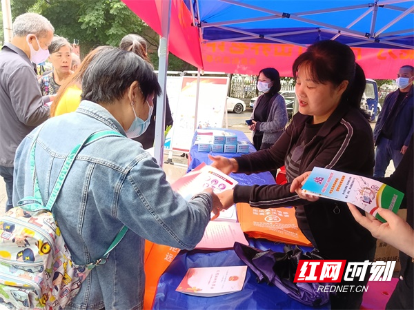 图二工作人员向居民介绍如何防范养老诈骗.jpg