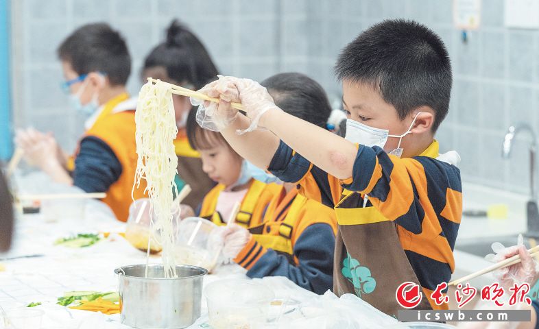 　　岳麓区博才小学“云厨房”，学生在尝试做凉面。