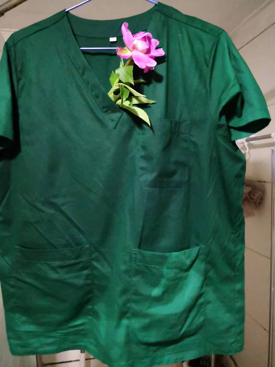 聂理会在汗水湿透的衣服上插着邻居送的牡丹花。受访者供图