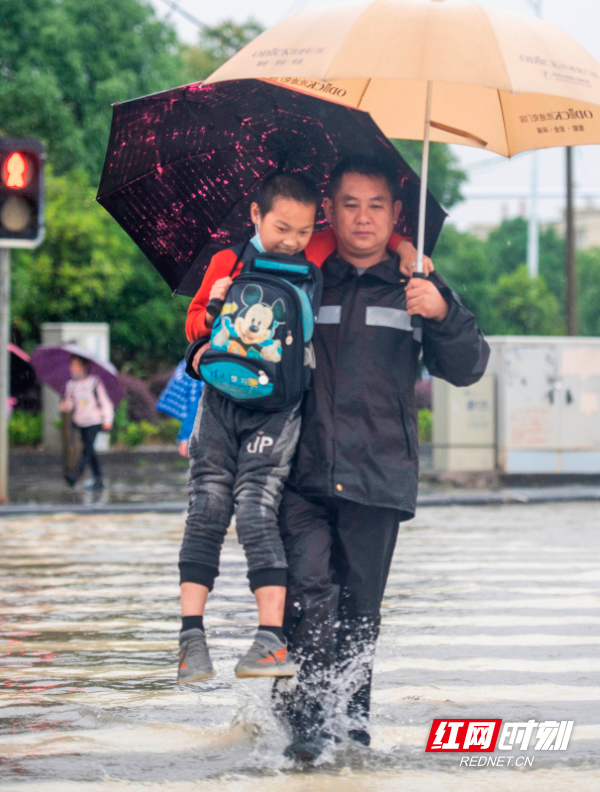 2022年5月23日，湖南省永州市道县高新技术产业开发区东环一路，城管工作人员背护学生过马路。 (5).jpg