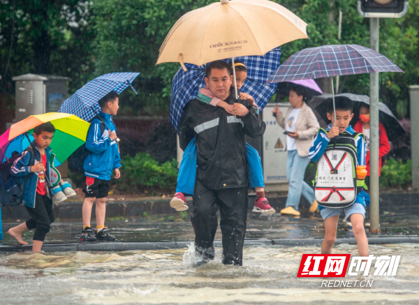 2022年5月23日，湖南省永州市道县高新技术产业开发区东环一路，城管工作人员在背护学生过马路。 (5).jpg