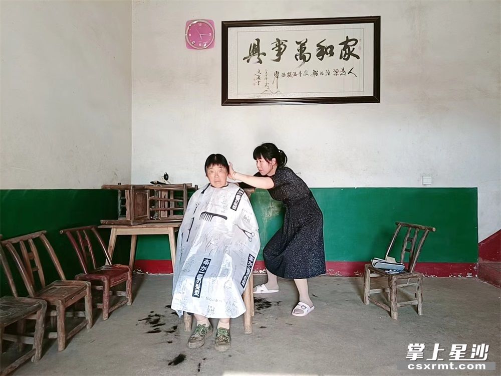 杨姣为婆婆理发。