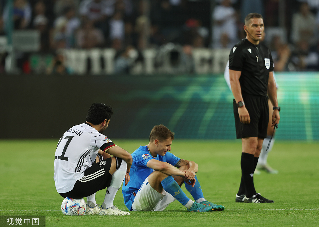 德国队中场京多安安慰失利的意大利球员。