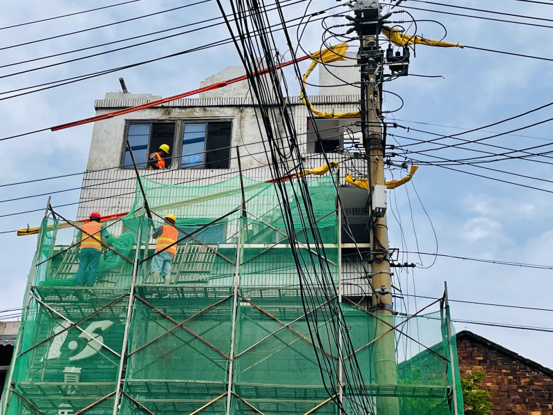 电力部门对紧邻违章建筑的电路做了绝缘保护，保障工人安全施工。长沙晚报全媒体记者 李卓 摄