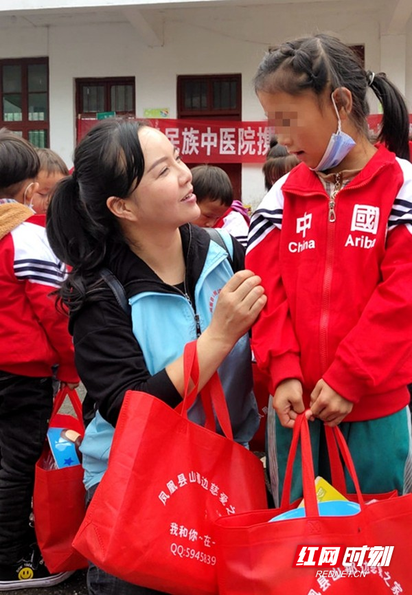 杨芬（左）到学校看望贫困家庭孩子。.jpg