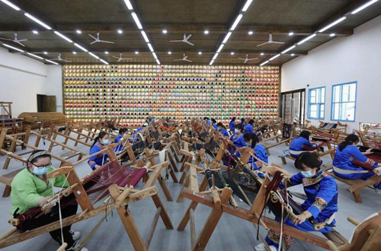 在武陵源区“妈妈工厂示范基地”乖幺妹土家织锦基地，“织女们”在忙碌着加工生产。吴勇兵摄.jpg