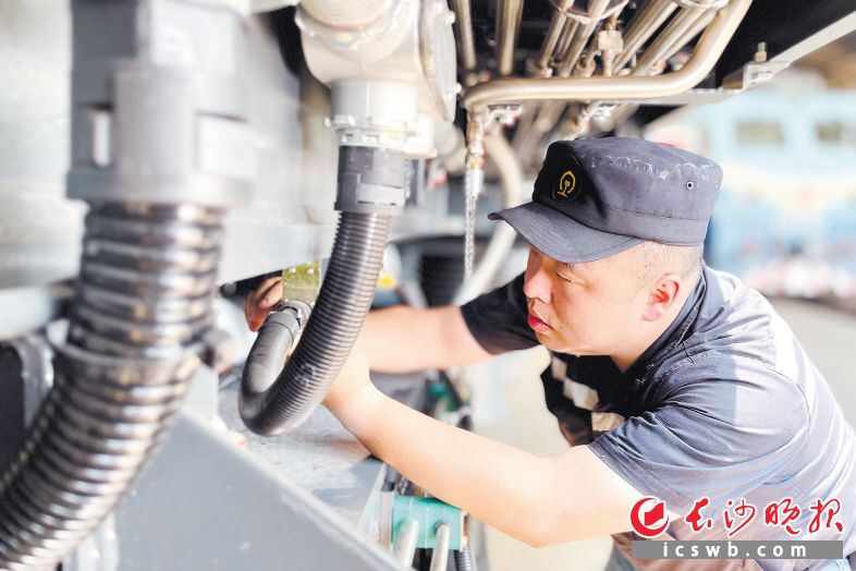 　　长沙电务段长沙车载车间副工长袁伟华正在检查机车线圈线缆接口。
