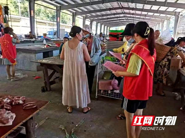 大学生在给村民发放宣传资料。（一）.jpg
