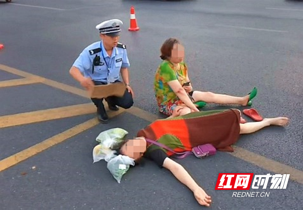 常德公安交警柳叶湖大队辅警熊小博为受伤倒地群众扇风降温.jpg