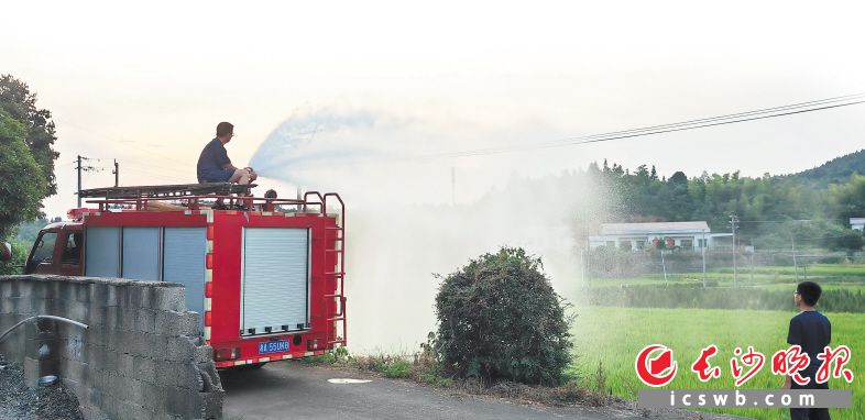 “火焰蓝”利用消防车浇灌田地，获得村民好评。长沙晚报通讯员 胡宇波 供图